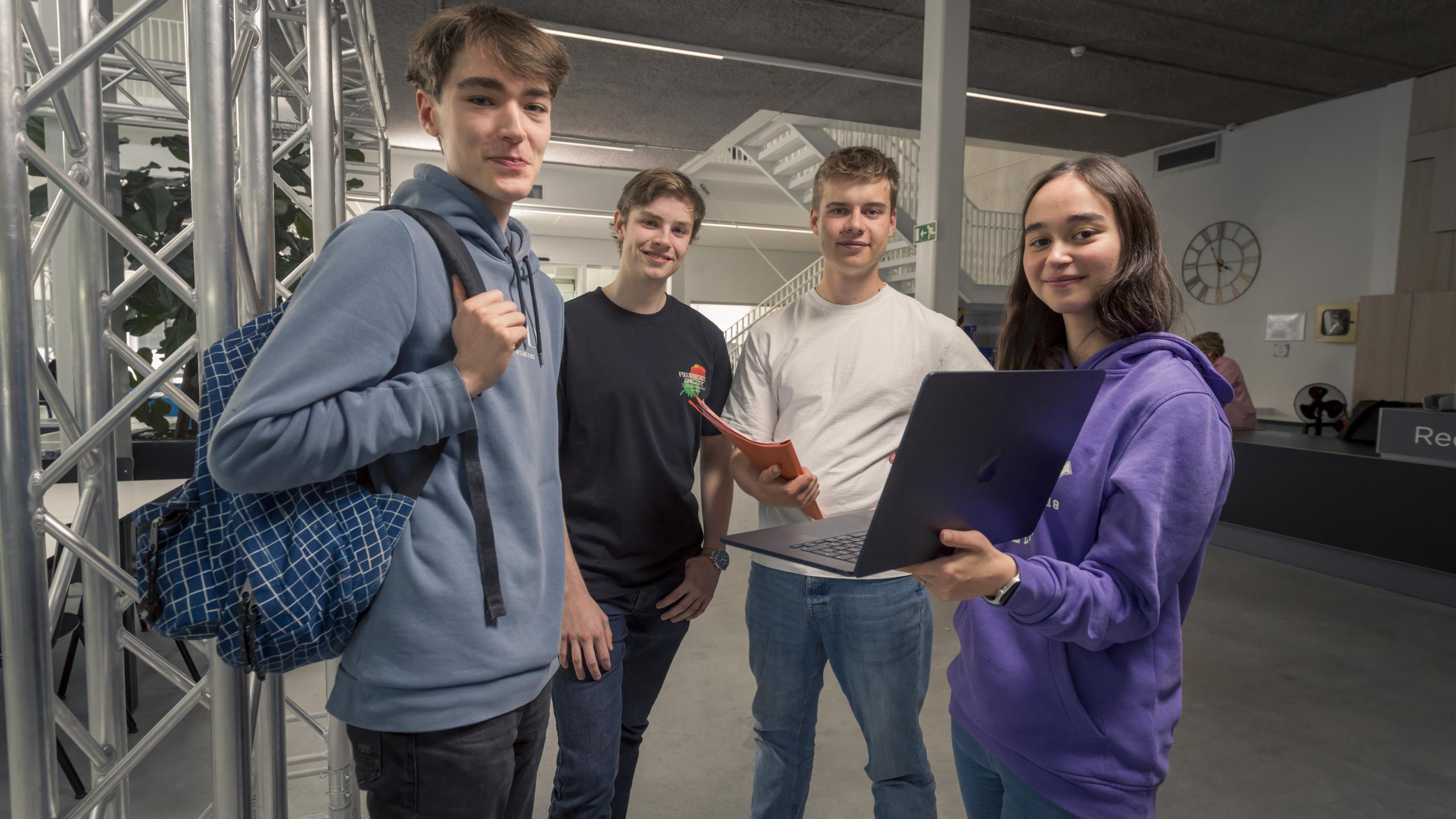 Studenten staan met een computer in de hand