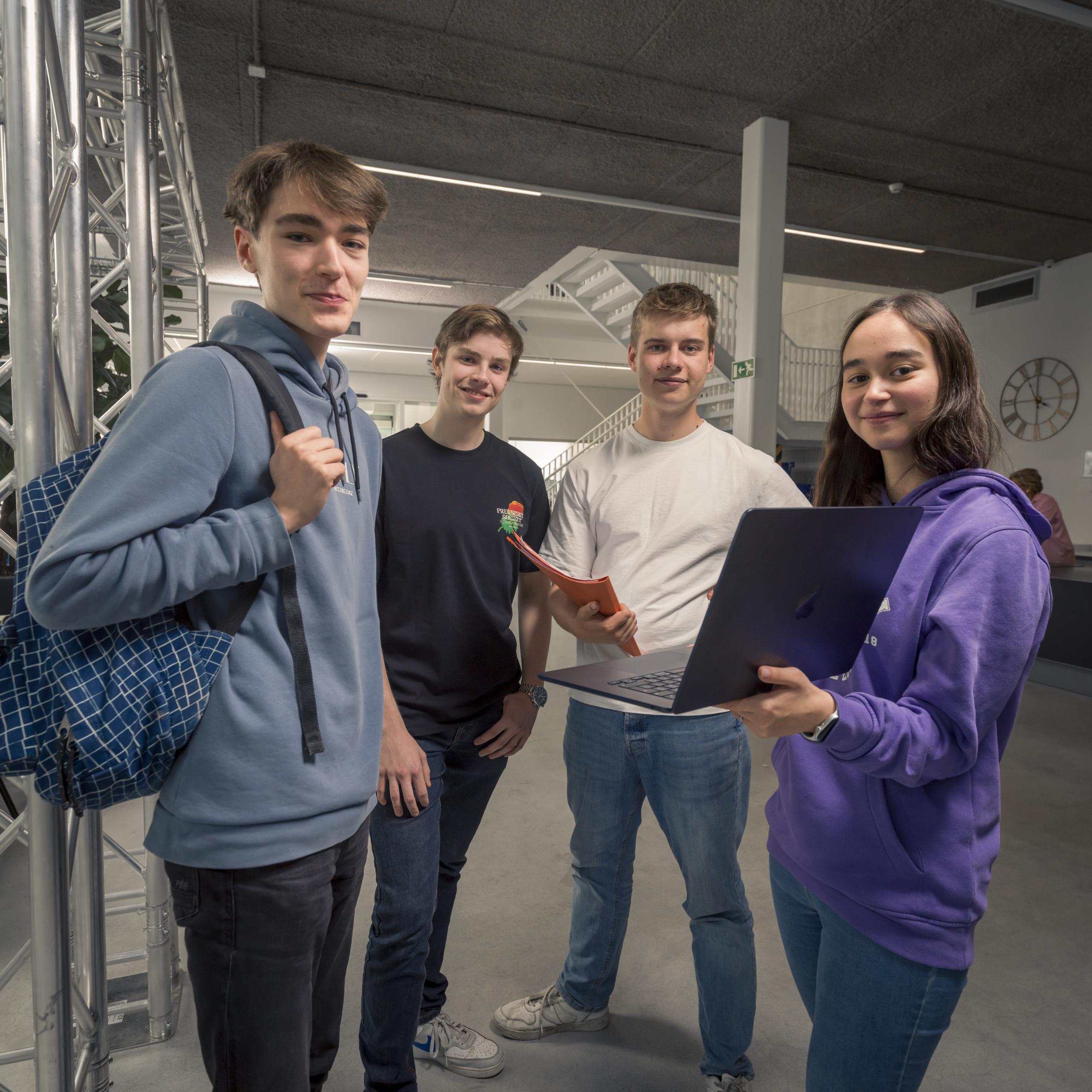 Studenten staan met een computer in de hand